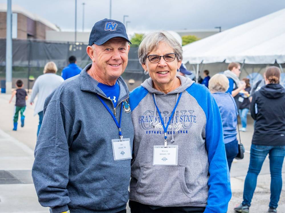 Two alumni from the class of 1968, pose for a photo at the Alumni Homecoming Tailgate.